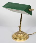 A vintage early 20th century gilt metal and enamel desk lamp, with green enamelled adjustable shade,