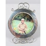 A round silver photograph frame with wire work foot and cresting, with red leather back,