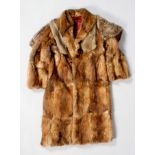 A vintage mink coat, of mud brown colour, with ark red satin lining and a rabbit cape with tie,