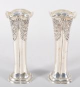 A pair of silver vases, of rounded squared shaped form, repousse decorated with swagged panels,