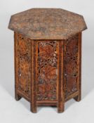 A carved Asian or Middle Eastern octagonal occasional table, carved with fruiting vine,