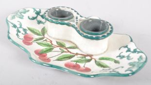 A Wemyss Ware inkstand, painted with red cherries, of scroll outline,