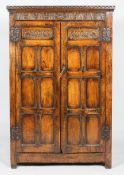 An oak 19th century wall cupboard, with dentil cornice above a carved stiff leaf and mask frieze,