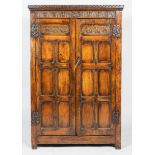 An oak 19th century wall cupboard, with dentil cornice above a carved stiff leaf and mask frieze,