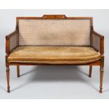 An Edwardian painted mahogany two seater Bergere sofa,