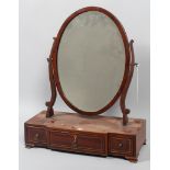 An early 19th century inlaid mahogany oval swing dressing table mirror,