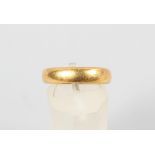 A yellow metal 4.5mm court shaped wedding ring. Hallmarked 22ct gold, Birmingham, 1925. Size: M 7.
