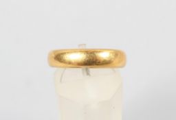 A yellow metal 4.5mm court shaped wedding ring. Hallmarked 22ct gold, Birmingham, 1925. Size: M 7.