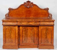 A Victorian mid 19th century mahogany sideboard with foliate carved waved gallery above two short