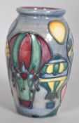 A small Moorcroft Balloons pattern vase of ovoid form decorated with tubelined balloons on a blue