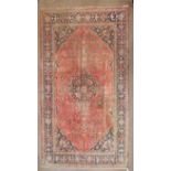 A wool rug with blue and pink geometric medallion,