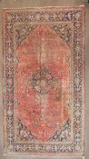 A wool rug with blue and pink geometric medallion,