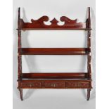 A Victorian mahogany three tier hanging shelf with pierced Gothic fretwork side panels