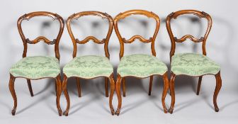 A set of four Victorian walnut balloon back dining chairs, mid 19th century,