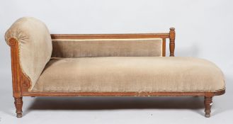 A Victorian oak chaise longue, the oak frame carved with foliate scrolls,