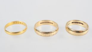 A collection of three wedding rings; Two hallmarked 9ct gold, One hallmarked 22ct gold.