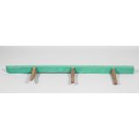 An 19th century oak saddle rack with green painted rack and three antler shaped hooks,