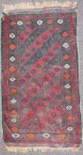 A claret ground wool prayer mat, woven with interlocking diamonds enclosing foliate motifs,