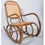 An early 20th Century Thonet style Czech bentwood rocker armchair having canework backrest and seat