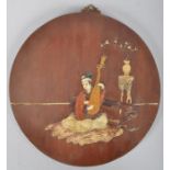 A Chinese wooden circular inlaid plaque with stone and marble with a figure playing a lute