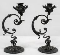 A pair of Art nouveau wrought steel and brass candlesticks, of foliate scrolled form,