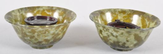 A pair of spinach jade bowls, each of flared form in mottled green hues,