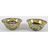 A pair of spinach jade bowls, each of flared form in mottled green hues,