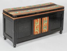 A Victorian ebonised ottoman-chest, of low rectangular section, with square recessed panelled front,