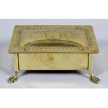 An Arts and Crafts brass box, the domed lid with engraved crest, on paw feet,