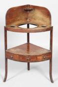 A late George III mahogany corner washstand, fitted drawer, onot swept supports,