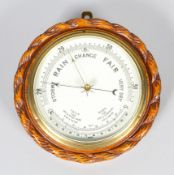 An early 20th century oak cased barometer, with white enamelled dial,