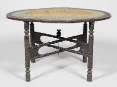A Benares table, the oval brass embossed tray within hardwood mount on folding stand,