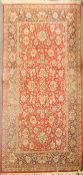 A wool rug with red ground with scrolling Persian flowers in blue and beige,