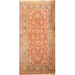 A wool rug with red ground with scrolling Persian flowers in blue and beige,