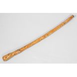 A 20th century naively carved hardwood African walking stick/cudgel, the grip modelled as a head,