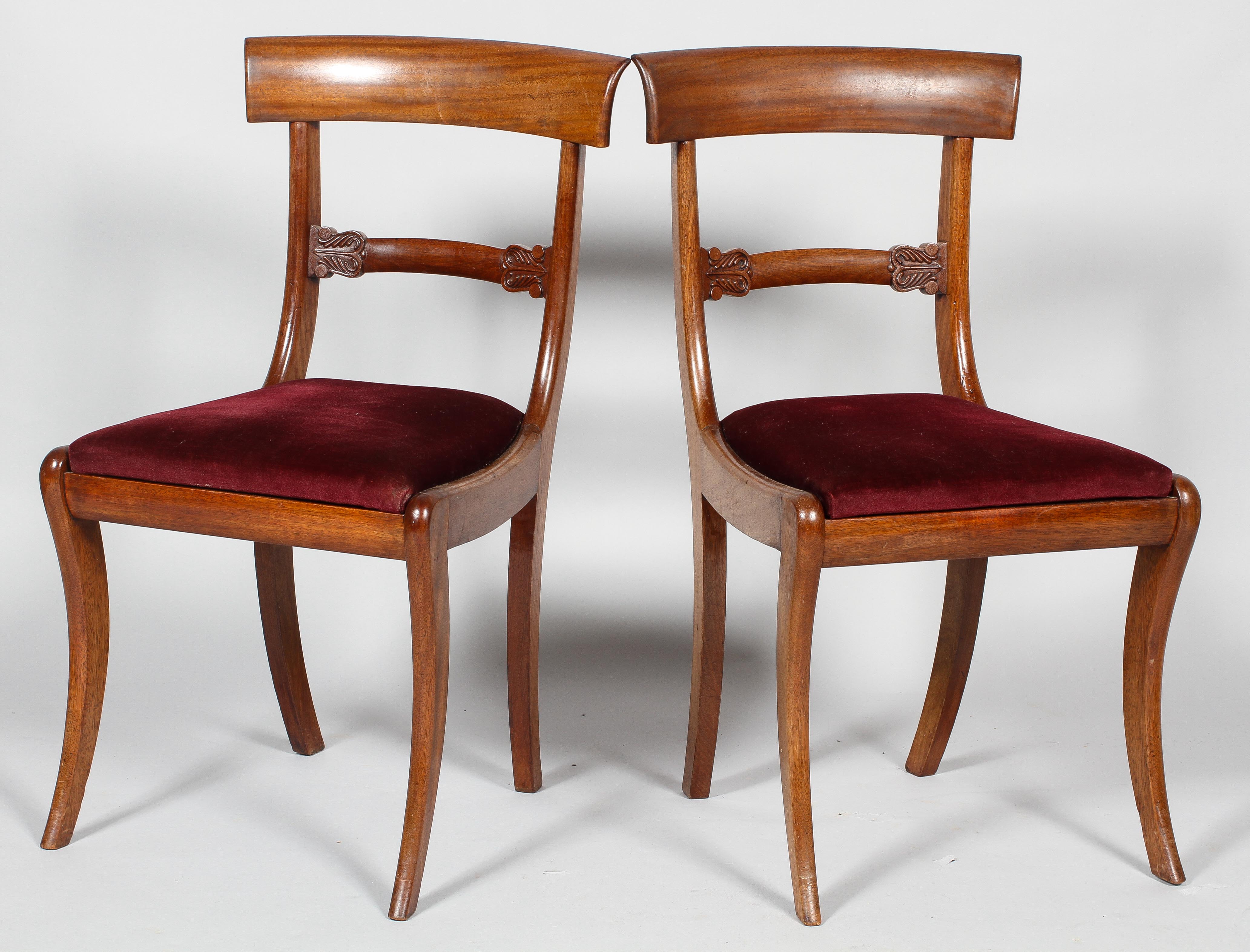 A pair of William IV mahogany dining chairs, with carved 'Trafalgar' top rail,
