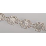 A white metal abstract linked bracelet, each set with a threepenny bit dating from 1917 to 1921.