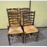 Four elm kitchen chairs with rush seats with scroll carved ladder backs