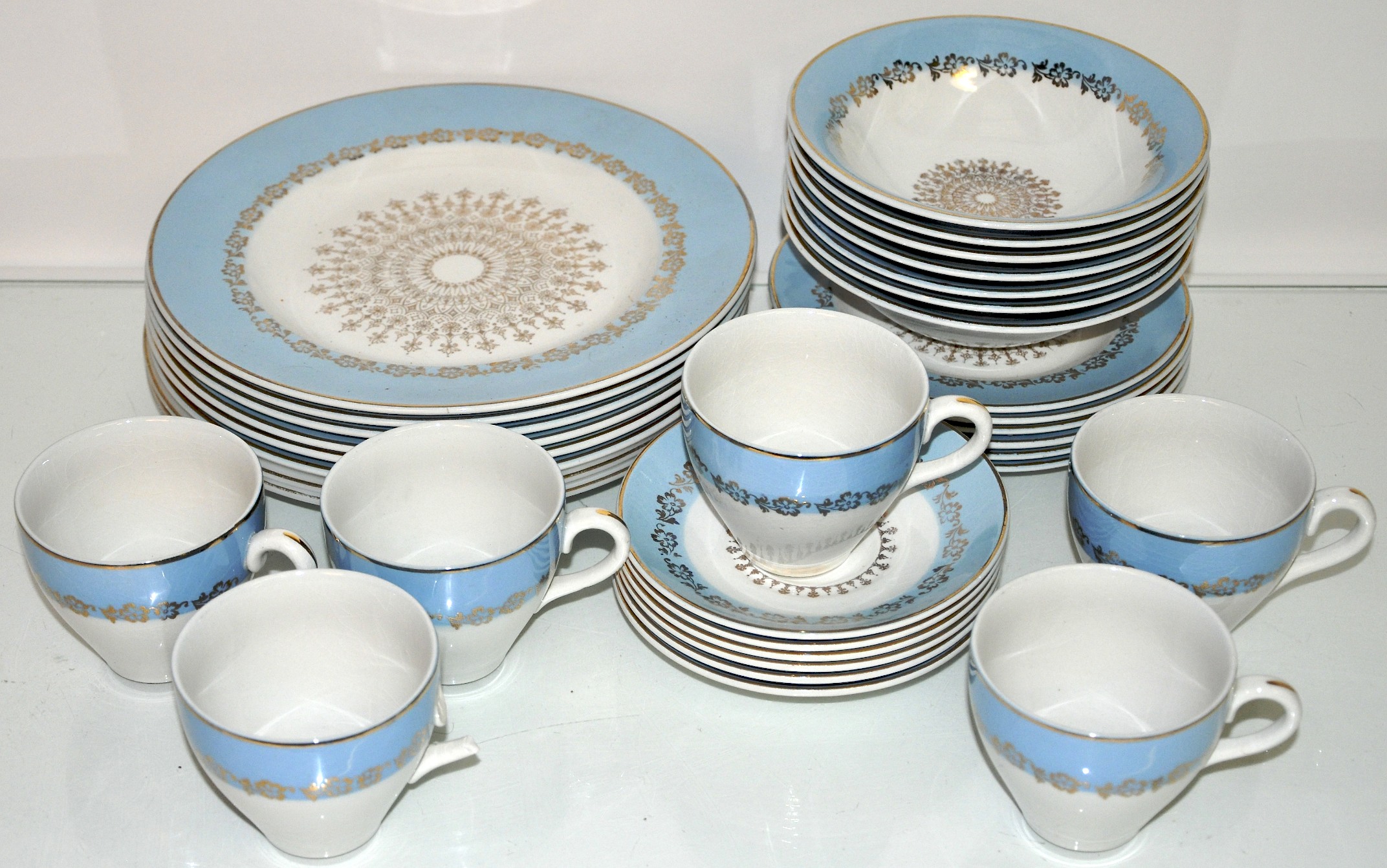 A china tea set with blue band and gilt decoration to include matching dinner plates