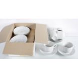 A group of white china cups and saucers boxed and unmarked