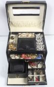 A mixed lot of costume jewellery in a case to include a selection of rings, brooches,