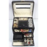 A mixed lot of costume jewellery in a case to include a selection of rings, brooches,