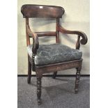 An early 19th century armchair with scrolled arms and turned legs,