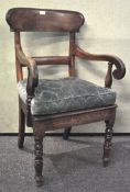 An early 19th century armchair with scrolled arms and turned legs,