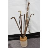 Eight walking sticks and a large earthenware jar 30cmH