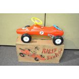 A boxed sit and drive car in style of rally car,