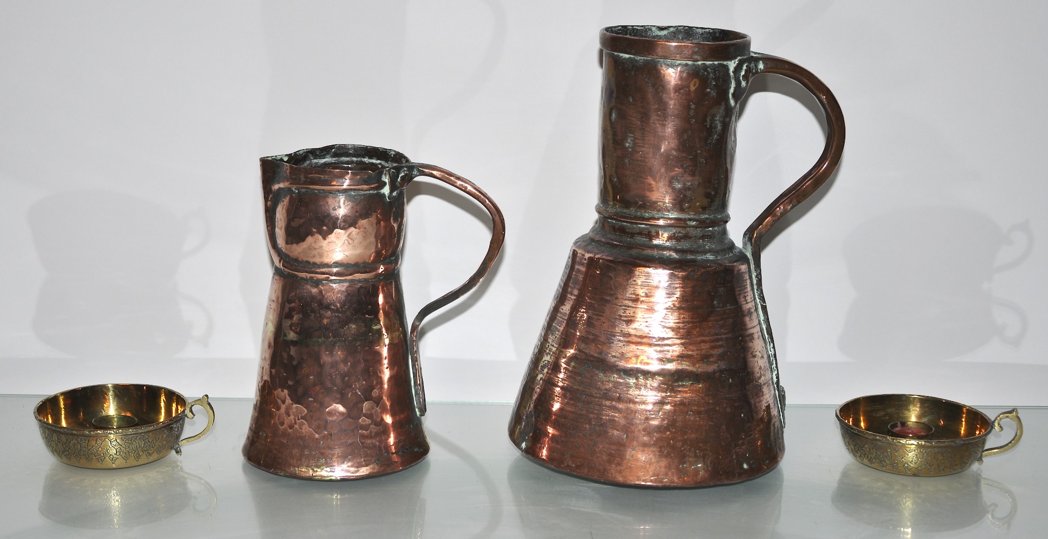 Two Iranian copper ewers and two brass candlesticks