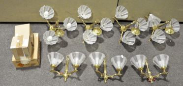 A group of brass and glass ceiling and wall lights