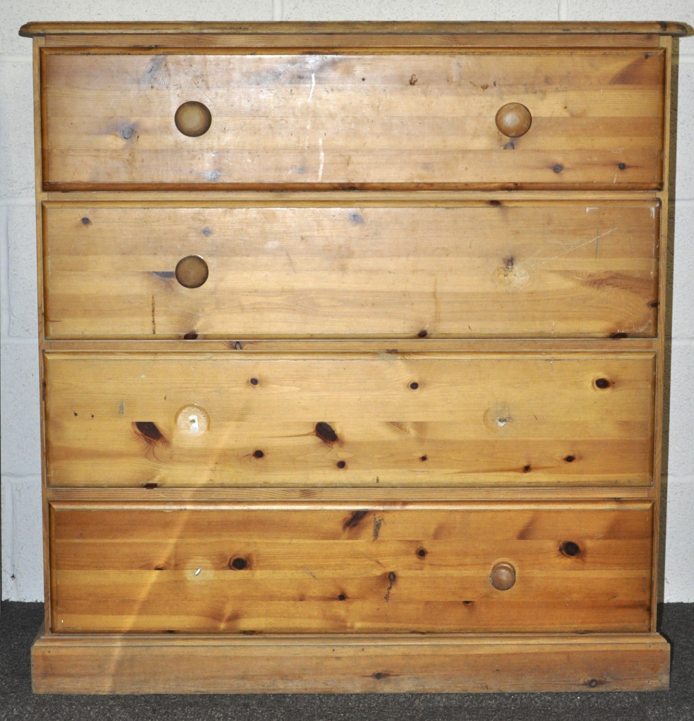 A pine chest of drawers having a run of four drawers, raised on a plinth base.