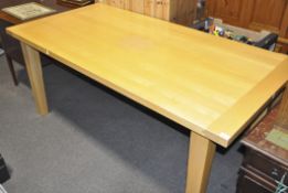 A plain beech wood plank top dining table on tapered legs,